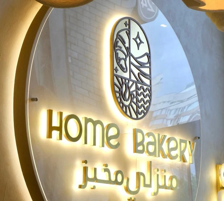 Световая вывеска Home Bakery с логотипом в зале кофейни